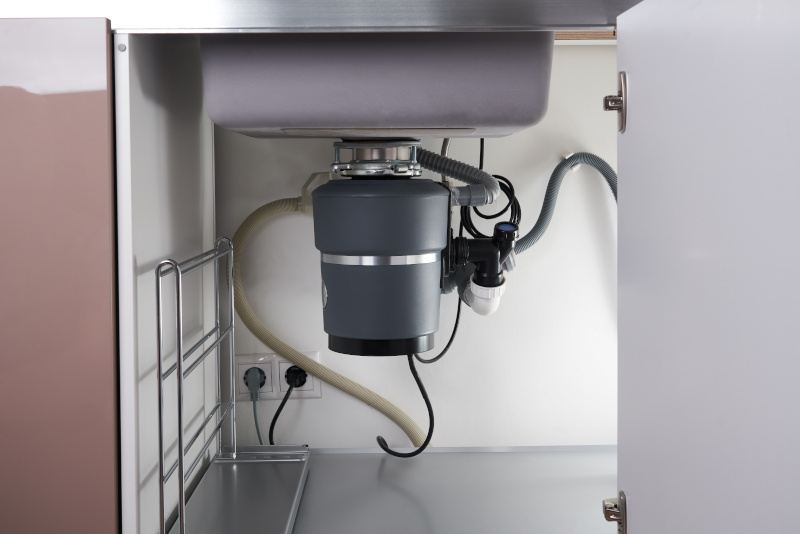 A garbage disposal installed under the sink, also known as a waste chopper or garburator